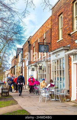 Les habitants de la région profitent d'une journée ensoleillée dans les cafés en plein air de Baldock High Street, Hertfordshire, Royaume-Uni Banque D'Images