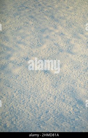 Texture de la neige au soleil.De la neige s'étend à l'extérieur.Temps froid.Surface inégale. Banque D'Images