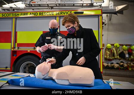 Le premier ministre d'Écosse, Nicola Sturgeon, montre comment administrer la naloxone par Paul Blackwood Scottish Fire and Rescue Service, commandant de groupe de East, North et South Ayrshire, lors d'une visite à la caserne de pompiers de Bathgate, En Écosse, les pompiers ont la possibilité de porter du naloxone pour aider à prévenir les décès dus à la drogue. Date de la photo: Mercredi 9 février 2022. Banque D'Images