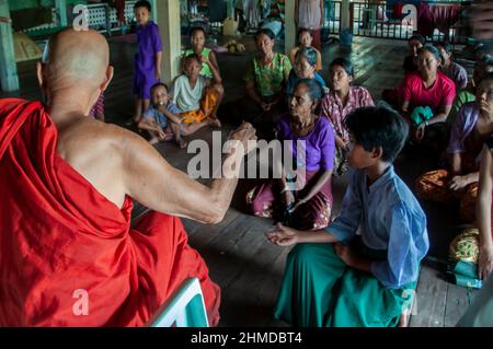 Le moine bouddhiste donner de l'argent aux personnes touchées par le cyclone dans un monastère de Kyauktan canton de Yangon Myanmar, Birmanie 15 Mai 2008 Banque D'Images