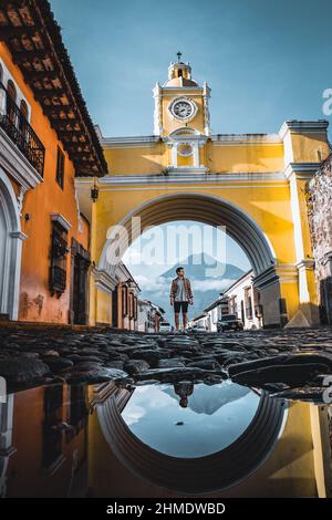 La route de l'Arche de Santa Catalina se reflète dans les rues en pierre de galets d'Antigua Guatemala, Guatemala. Banque D'Images