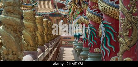 Chonburi, Thaïlande - 05 février 2022 : panoramique de piliers et de couloir sculptés de dragons dans un temple de style chinois. Wihan Thep Sathit Phra Ki Ti Chaloe Banque D'Images