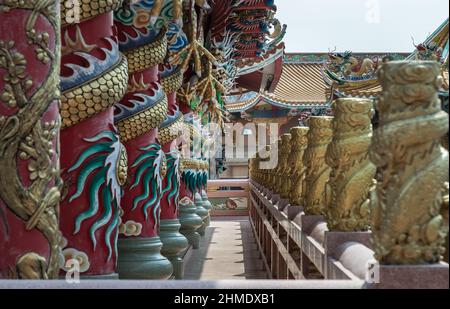 Chonburi, Thaïlande - 05 février 2022 : piliers et couloir sculptés de dragons dans un temple de style chinois. Wihan Thep Sathit Phra Ki Ti Chaloem, sélectif pour Banque D'Images