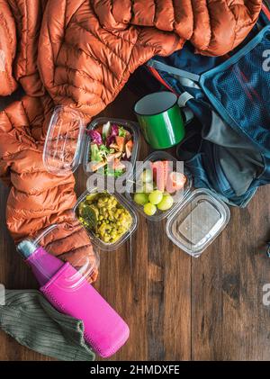 Repas préparés à la maison et emballés dans des boîtes à emporter : salade de tomates, fruits, fraises et raisins, viande en sauce aux pois. Préparation d'un Banque D'Images