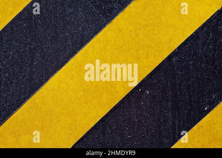 Surface métallique peinte avec des bandes noires et jaunes Banque D'Images