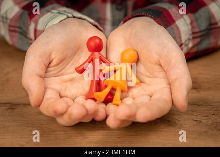 Figurines de jeune famille sans enfant dans les mains humaines. Concept de famille valeurs photo Banque D'Images