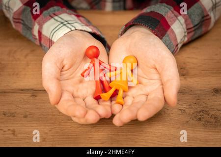 Figurines de jeune famille sans enfant dans les mains humaines. Concept de valeurs familiales Banque D'Images