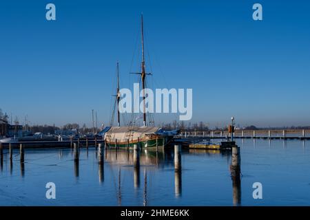 Un voilier dans une marina fermé pour l'hiver.Eau bleue et ciel bleu clair Banque D'Images