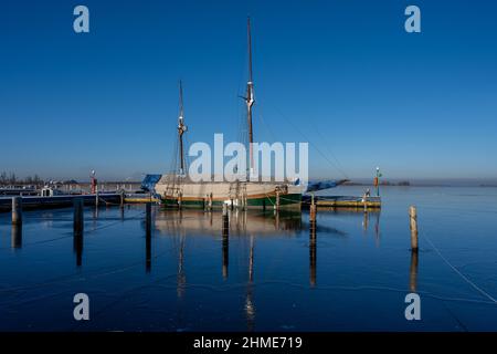 Un voilier dans une marina fermé pour l'hiver.Eau bleue et ciel bleu clair Banque D'Images