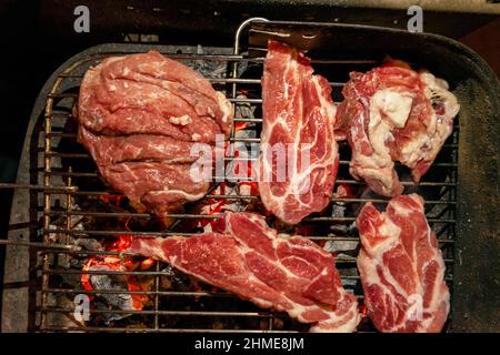 Barbecue de porc en fin de soirée avec des poutres de charbon de bois. Côtelettes de bonne couleur et savoureuses. Concept gastronomique Banque D'Images