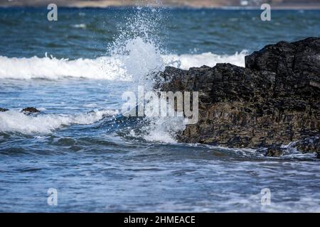 Des vagues s'écrasant sur les rochers le long de la côte à Rhosneigr Beach sur Anglesey Banque D'Images