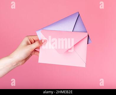 Enveloppes à main avec un message d'accueil de Saint-Valentin ou des chèques-cadeaux sur fond rose. Photo de haute qualité Banque D'Images