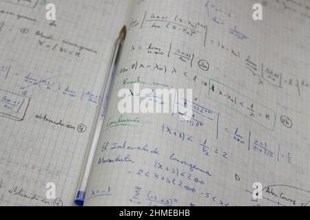 Image de quelques feuilles avec des exercices résolus de limites mathématiques sur lesquelles il y a un stylo bleu utilisé Banque D'Images