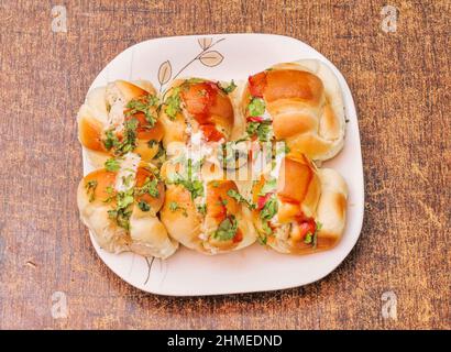 Des petites bouchées de poulet dans un plat sur fond de bois sombre vue du dessus Banque D'Images