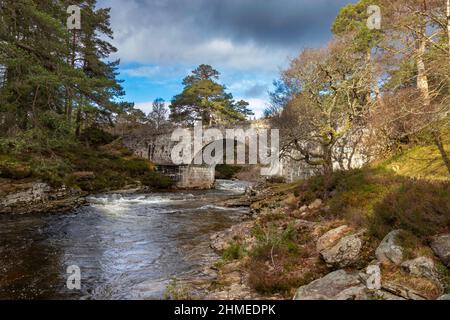 RIVER LUI MAR LODGE ESTATE BRAEMAR SCOTLAND LE VIEUX PONT EN PIERRE AU-DESSUS DE LA RIVIÈRE LUI À LA FIN DE L'HIVER Banque D'Images