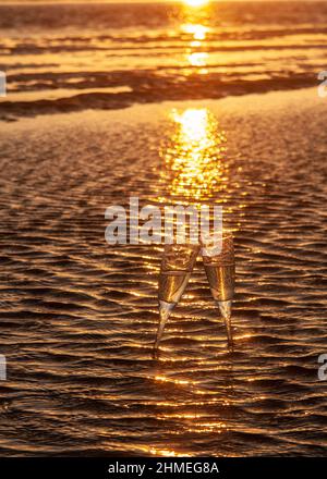 Deux couches de champagne sur les rives de la plage de Tarifa au coucher du soleil Banque D'Images