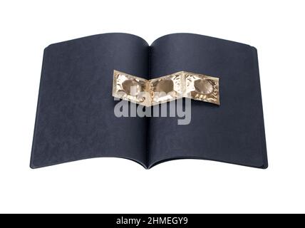 carnet en carton noir avec condoms dorés sur fond blanc Banque D'Images