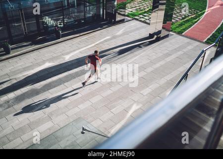Sportif anonyme en forme de course le long du trottoir en ville Banque D'Images