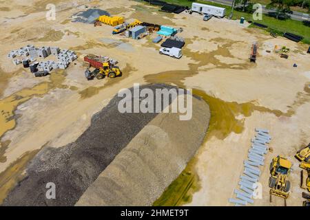 Vue aérienne drainage tuyaux de système d'égout empilés dans le sol pendant la plomberie avec la préparation du terrain pour le chantier de construction Banque D'Images