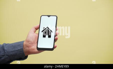Personne tenant un téléphone avec l'icône de prêt hypothécaire Banque D'Images