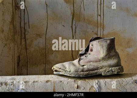 Chaussures de travail en cuir cloué sur un mur, chaussures pourries, épave de chaussures, chaussures pourries, chaussures usées, patin usé, ancien patin Banque D'Images