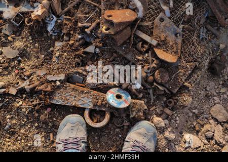 Pieds au milieu de piles de ferraille, de déchets de fer, de ferraille, de chantier de ferraille, de mise au rebut Banque D'Images