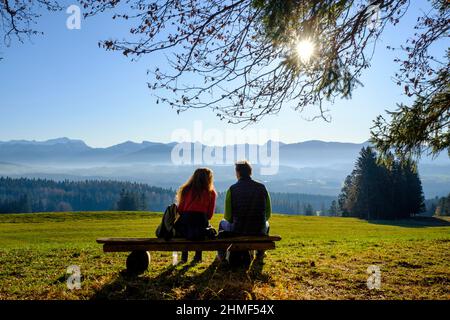 Randonneurs prenant une pause sur un banc, sur le Panoramaweg, à Sonnenbichel, Schoenberg, près de Rottenbuch, Pfaffenwinkel, haute-Bavière, Bavière, Allemagne Banque D'Images