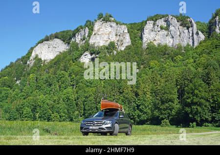 Mercedes avec canoë en bois de cèdre sur le toit en face des rochers dans la vallée du Danube, Hausen im Tal, quartier de Sigmaringen, Bade-Wurtemberg, Allemagne Banque D'Images