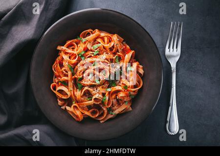 Vue de dessus de spaghetti avec sauce tomate sur fond noir Banque D'Images