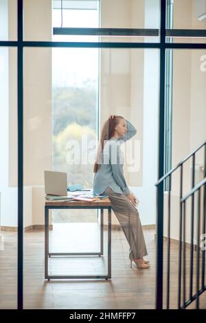 Une femme qui pense s'est penchée sur un bureau Banque D'Images