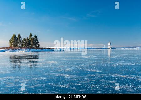 Le phare du grand Marais dans le Minnesota en hiver. Le lac supérieur est gelé autour des marinas. Banque D'Images