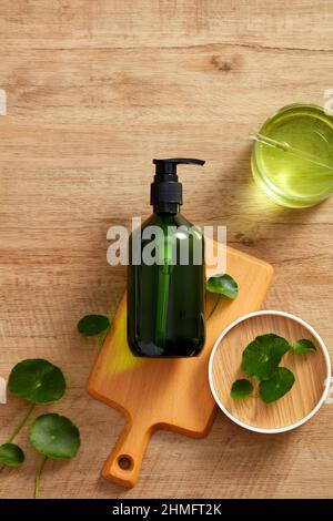 Extrait de Centella asiatica et modèle de pot cosmétique en planche à découper en bois et un fond en bois marron pour la publicité centella asiatica , top vie Banque D'Images