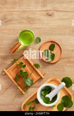 Extrait de Centella asiatica et modèle de pot cosmétique en planche à découper en bois et un fond en bois marron pour la publicité centella asiatica , top vie Banque D'Images