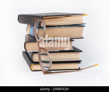 Les livres sont empilés avec des lunettes. Éducation, loisirs de lecture, recherche de données, concept d'obtention de connaissances. Photo de haute qualité Banque D'Images