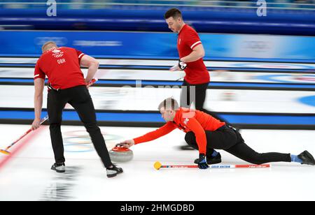 Bruce Mouat (à droite), en Grande-Bretagne, joue un tir avec les coéquipiers Bobby Lammie (à gauche) et Hammy McMillian lors de la session ronde des hommes 2 contre l'Italie au cours de la sixième journée des Jeux Olympiques d'hiver de 2022 à Beijing au Centre aquatique national en Chine. Date de la photo : jeudi 10 février 2022. Banque D'Images