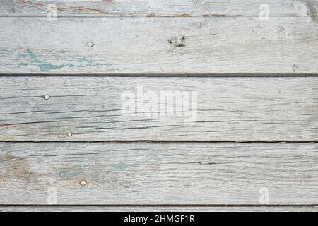 Base en bois antique avec peinture écaillée, tons gris, traces de rouille sur les lacets. Banque D'Images