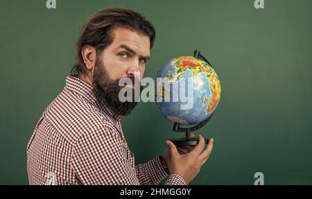 homme barbu mature enseignant en classe scolaire avec tableau noir, géographie Banque D'Images