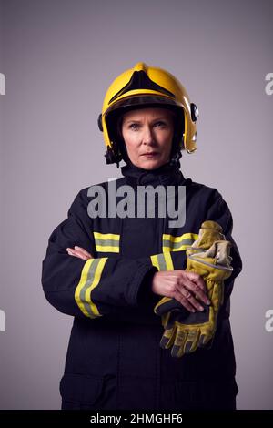 Studio Portrait d'un pompier féminin sérieux et mature contre fond plat Banque D'Images