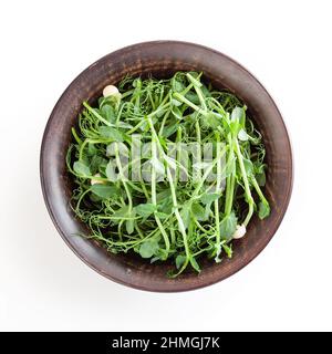 Microverts frais de pois dans un bol en céramique isolé sur fond blanc avec passe-cheveux Banque D'Images