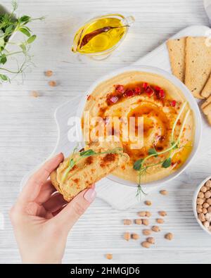 Petit déjeuner sain avec houmous maison sur fond de bois blanc. En-cas pour femme. Régime alimentaire et en-cas sains. Banque D'Images