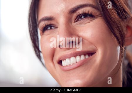 Gros plan Portrait d'une femme à l'aspect naturel et détendu souriant à la maison Banque D'Images