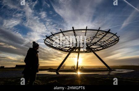 Haslingden, Lancashire, Royaume-Uni, mercredi 09 février 2022. Un marcheur s'arrête pour admirer le soleil couchant au panopticon de Halo au-dessus de la ville de Haslingden, Banque D'Images