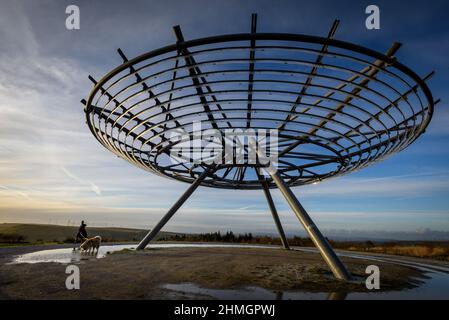 Haslingden, Lancashire, Royaume-Uni, mercredi 09 février 2022. Un marcheur s'arrête pour admirer le soleil couchant au panopticon de Halo au-dessus de la ville de Haslingden, Banque D'Images