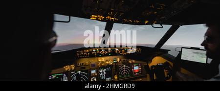 des professionnels flous pilotant un avion le soir au coucher du soleil, bannière Banque D'Images