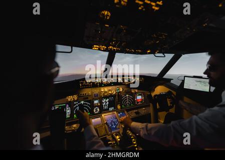 des professionnels flous pilotant un avion le soir au coucher du soleil Banque D'Images