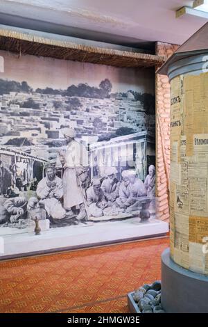 Une récréation d'une vieille publicité, un panneau d'affichage pour les journaux et une vieille photo des malades qui cherchent des soins dans un bazar à Samarkand. Au Museu Banque D'Images