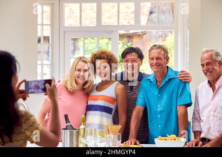 Des amis seniors en vacances d'été se rencontrent pour prendre un verre dans la Villa de vacances Prenez des photos sur téléphone portable Banque D'Images