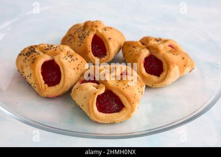 Enveloppes de biscuits au beurre croquant faits maison avec confiture et graines de pavot sur une assiette en verre transparent Banque D'Images