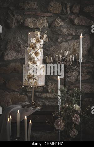 Encore une vie de délicieux gâteau de mariage à trois niveaux décoré de fleurs, tons gris Banque D'Images