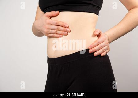 Une femme montre l'emplacement du pancréas et de la rate, le gros intestin. Gros plan de l'abdomen. Banque D'Images